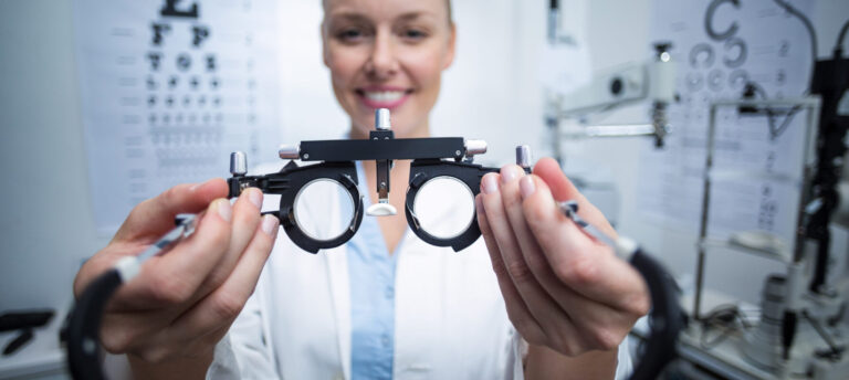 smiling female optometrist holding messbrille scaled e1604998458701